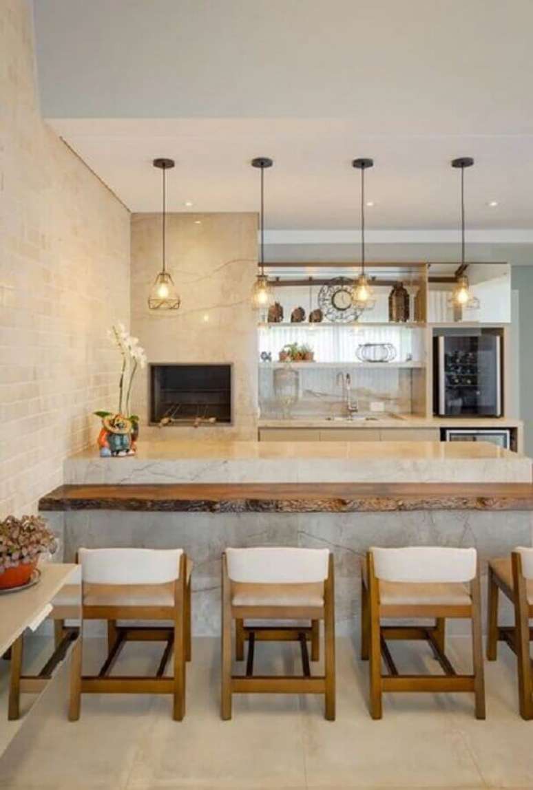 25. Decora&ccedil;&atilde;o em cores neutras com lustre pendente para &aacute;rea gourmet com bancada de madeira r&uacute;stica &ndash; Foto: Architrends