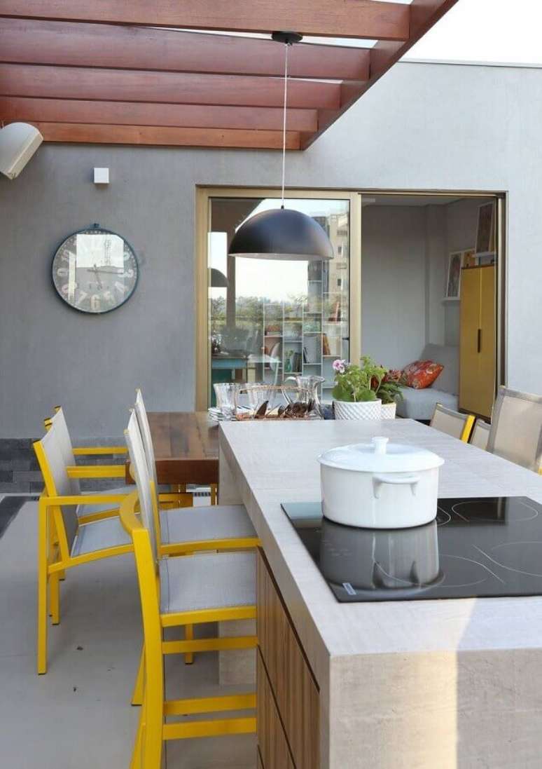 42. Lustre para área gourmet externa decorada com cadeiras pretas para ilha com cooktop – Foto: Pinterest