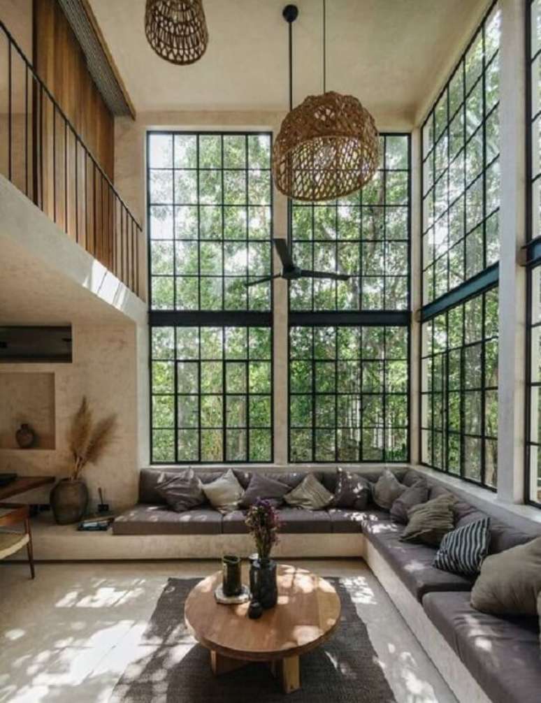 63. A paisagem externa pode ser vista de dentro do im&oacute;vel por meio das janelas amplas do im&oacute;vel com p&eacute; direito duplo. Fonte: Pinterest