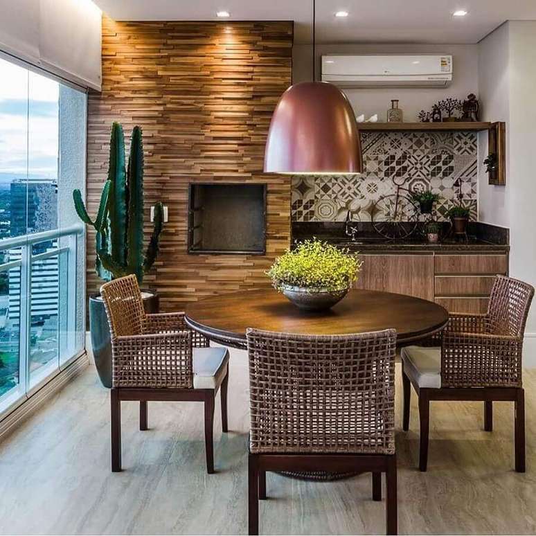 13. Decora&ccedil;&atilde;o com lustre para &aacute;rea gourmet com revestimento de madeira e mesa redonda &ndash; Foto: Pinterest
