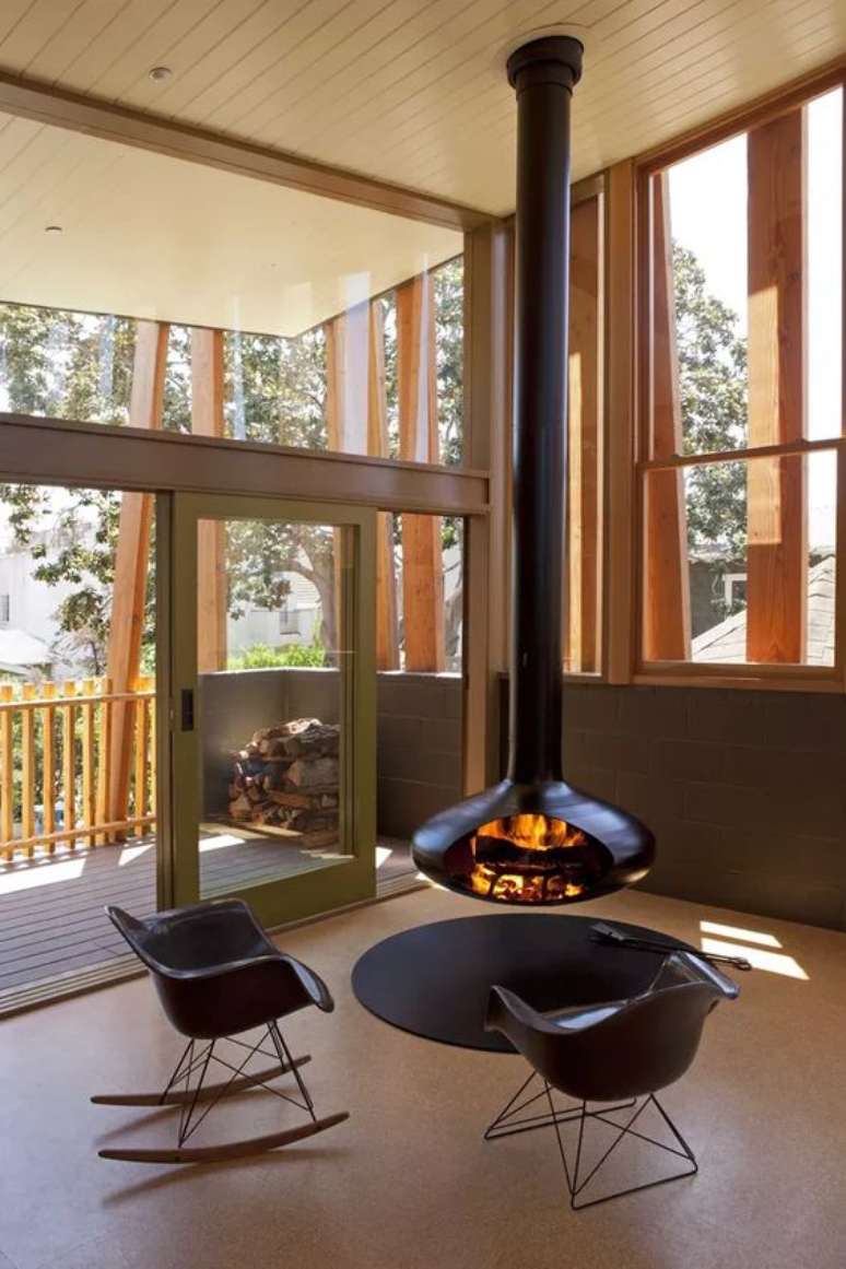50. Decora&ccedil;&atilde;o com lareira suspensa e cadeira preta de balan&ccedil;o &ndash; Foto Casa Vogue