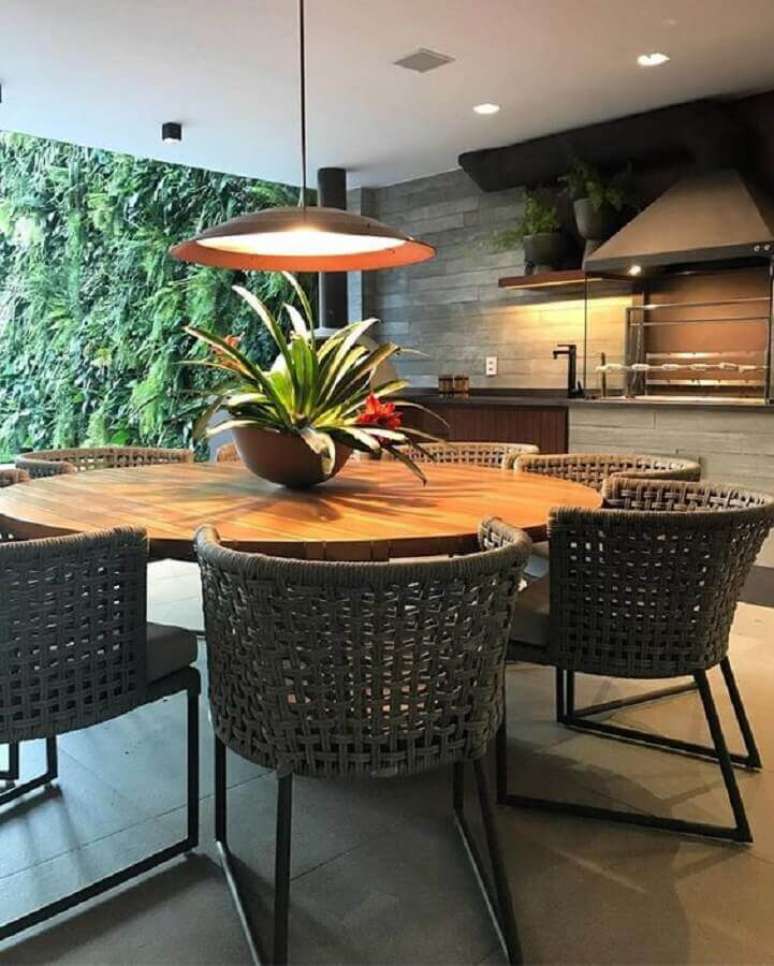 43. Lustre para área gourmet externa decorada com jardim vertical e mesa redonda – Foto: Casa de Valentina