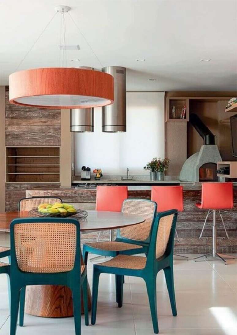 39. Lustre para área gourmet decorada com revestimento de madeira e cadeiras azuis – Foto: Pinterest