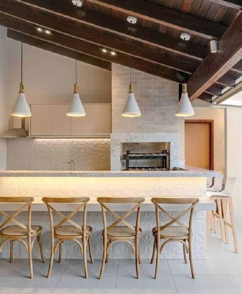45. Lustre para &aacute;rea gourmet externa decorada com revestimento 3D e banquetas de madeira &ndash; Foto: Fashion Bubbles