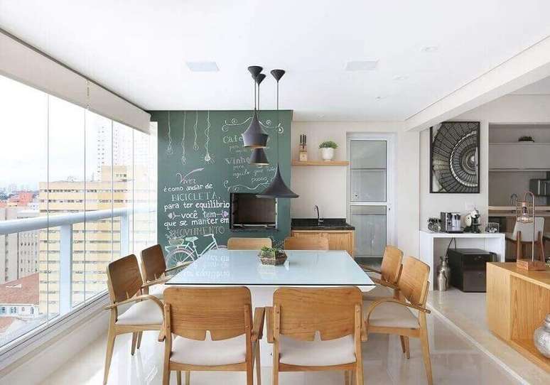 55. Lustre pendente para área gourmet decorada com mesa quadrada e parede de tinta lousa – Foto: Renata Cafaro
