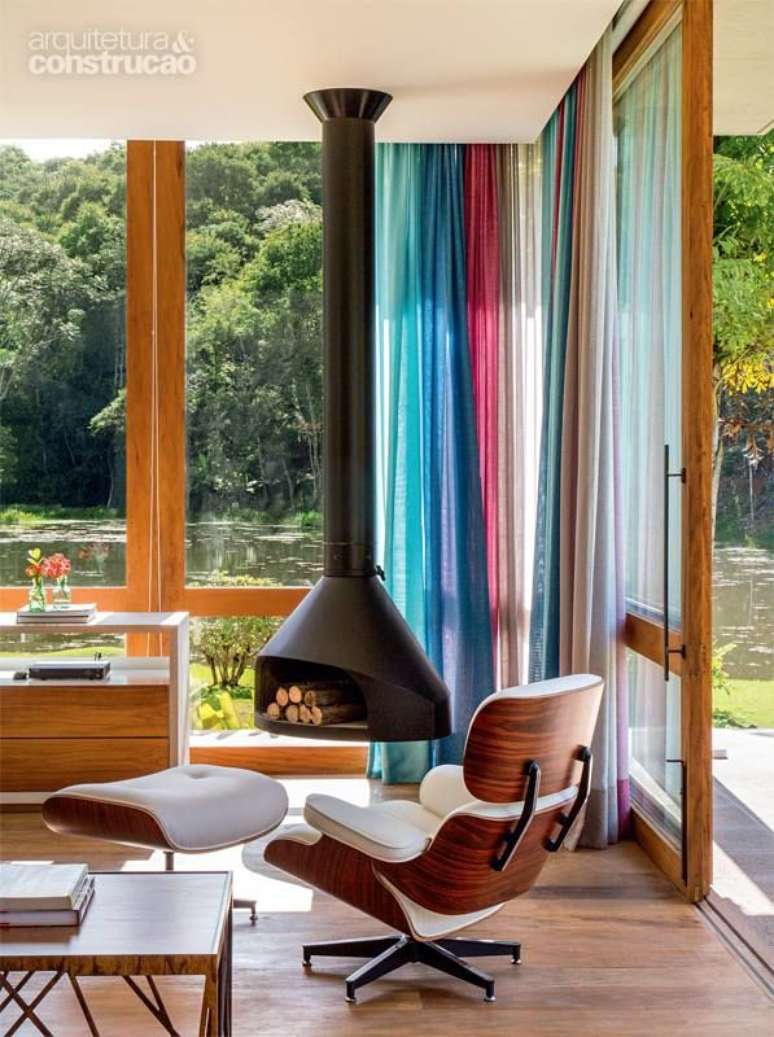 35. Sala com lareira suspensa perto da poltrona com puff &ndash; Foto Casa Abril