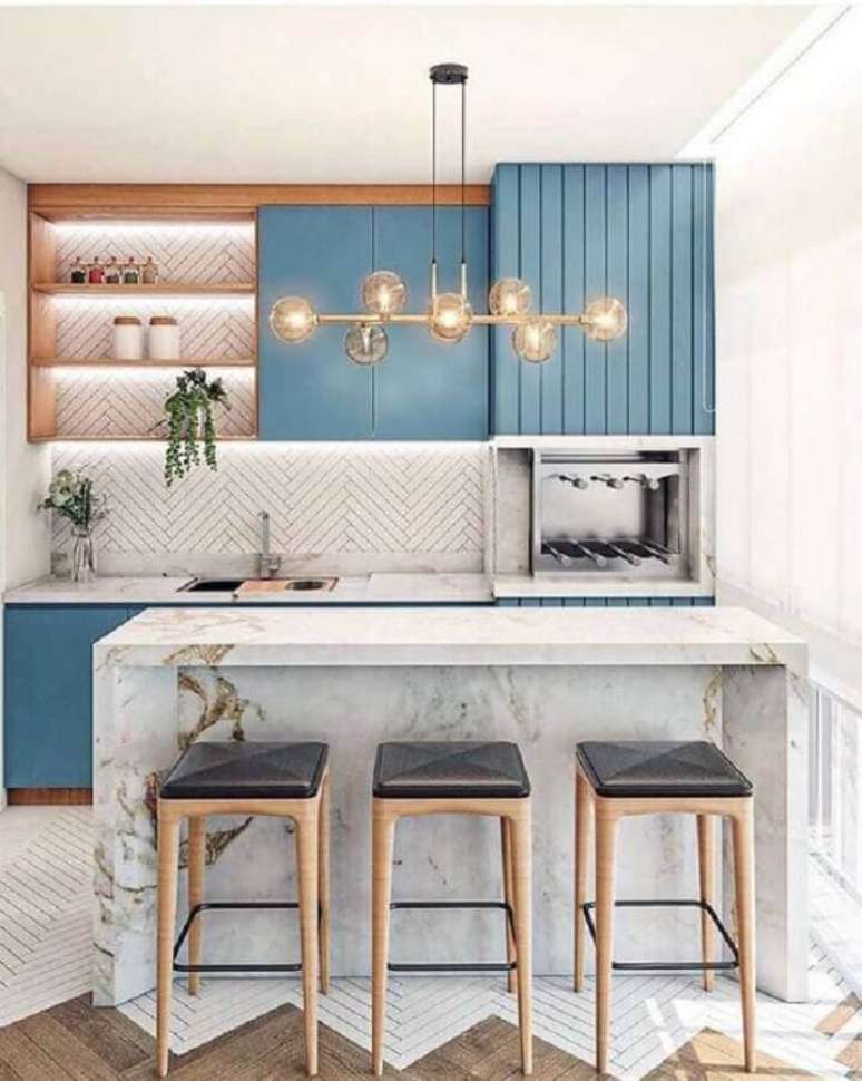 8. Decora&ccedil;&atilde;o com lustre moderno para &aacute;rea gourmet planejada com bancada de m&aacute;rmore e arm&aacute;rios azuis &ndash; Foto: Fashion Bubbles