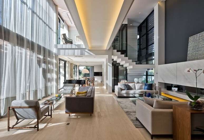 58. A cortina p&eacute; direito duplo cinza se estende por toda a sala do im&oacute;vel. Projeto de Leonardo Muller