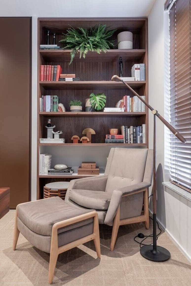47. Poltrona confortável para leitura em sala decorada com estante de nichos – Foto: VOA Arquitetura