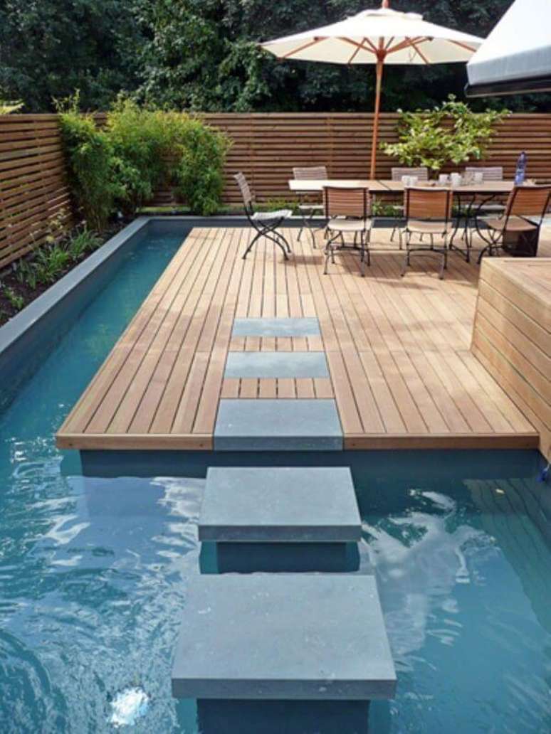 58. Guarda sol para piscinas modernas com mesa grande para receber amigos – Foto Pinterest