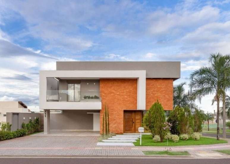 Fachada de casa térrea contemporânea em tons de cinza e com pedras