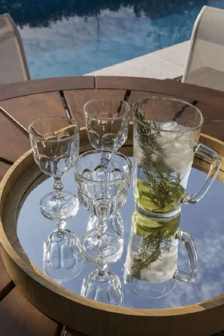 16. A bandeja espelhada para bar traz um toque de requinte para a decora&ccedil;&atilde;o. Projeto de Studio Deux