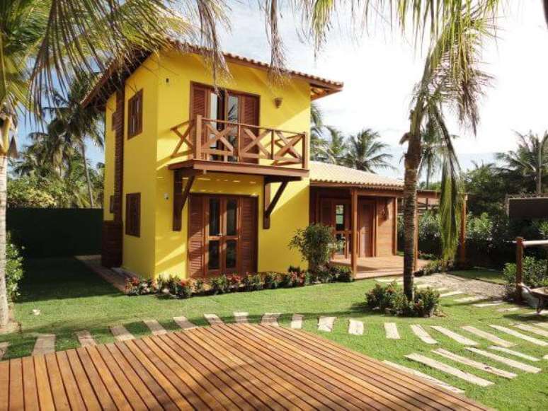 81. Casa com fachada amarela e janelas de madeira – Foto Pinterest