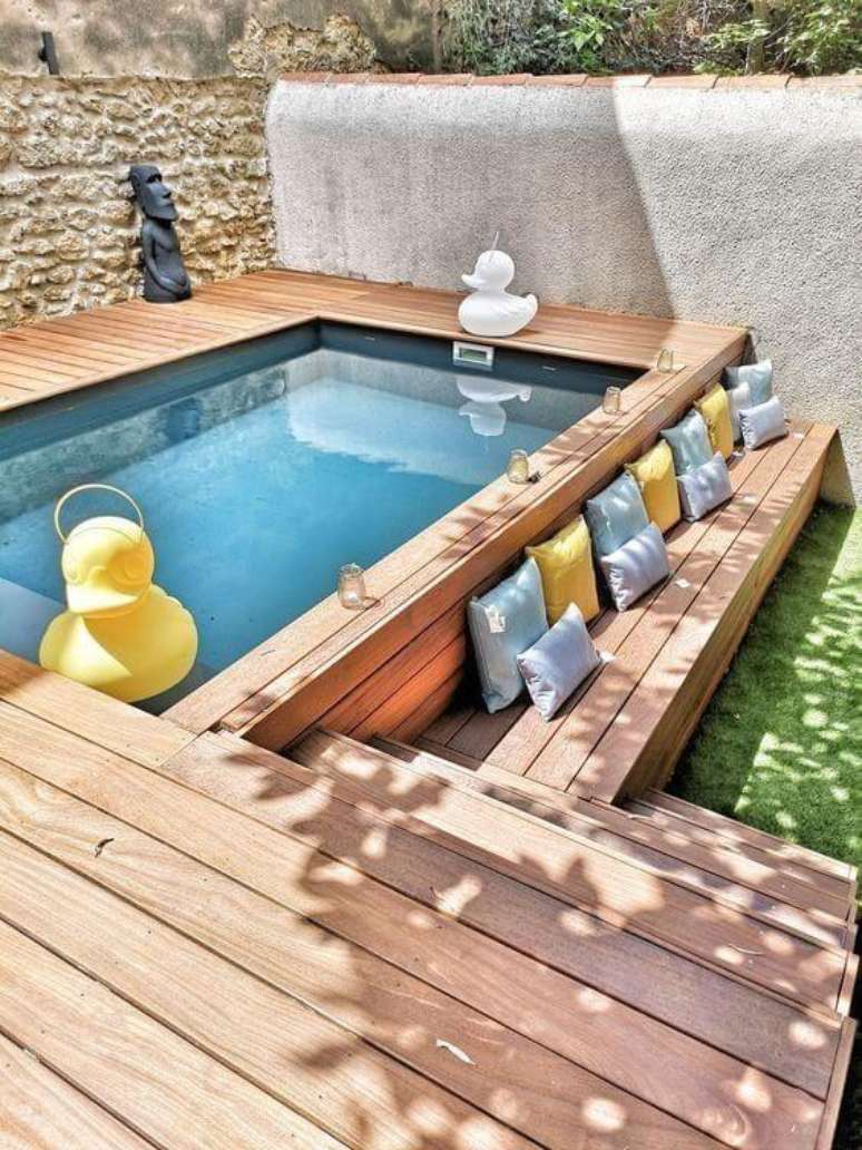 81. Piscinas modernas com deck de madeira e almofadas coloridas para deixar o ambiente mais confort&aacute;vel &ndash; Foto Pinterest