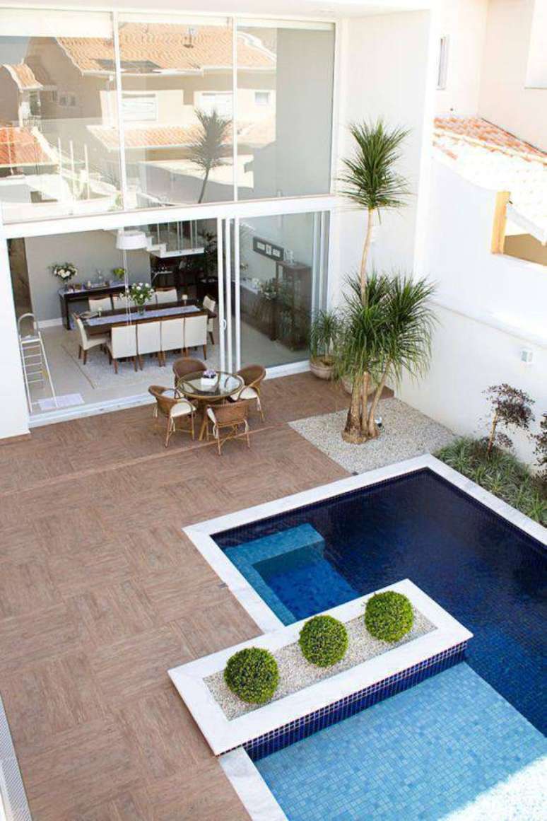 83. Piscinas modernas com borda branca e piso antiderrapante para colocar móveis de madeira resistentes – Foto Homify