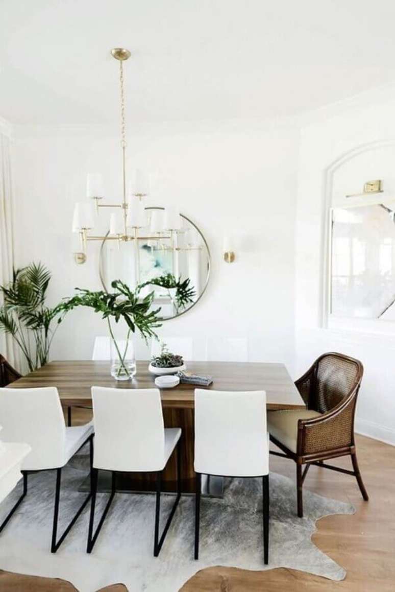 7. Poltrona confortável para sala de jantar branca decorada com espelho redondo – Foto: The Ever Girl