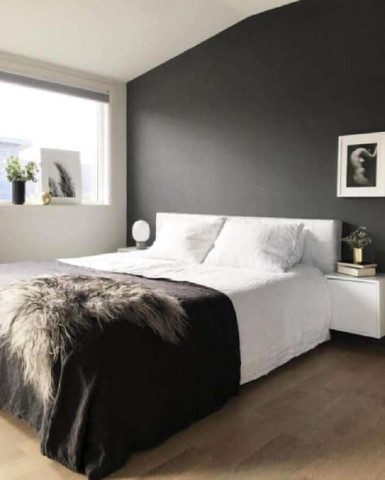 6. Decoração minimalista para quarto de casal preto e branco com lustre dourado – Foto: Home Bunch