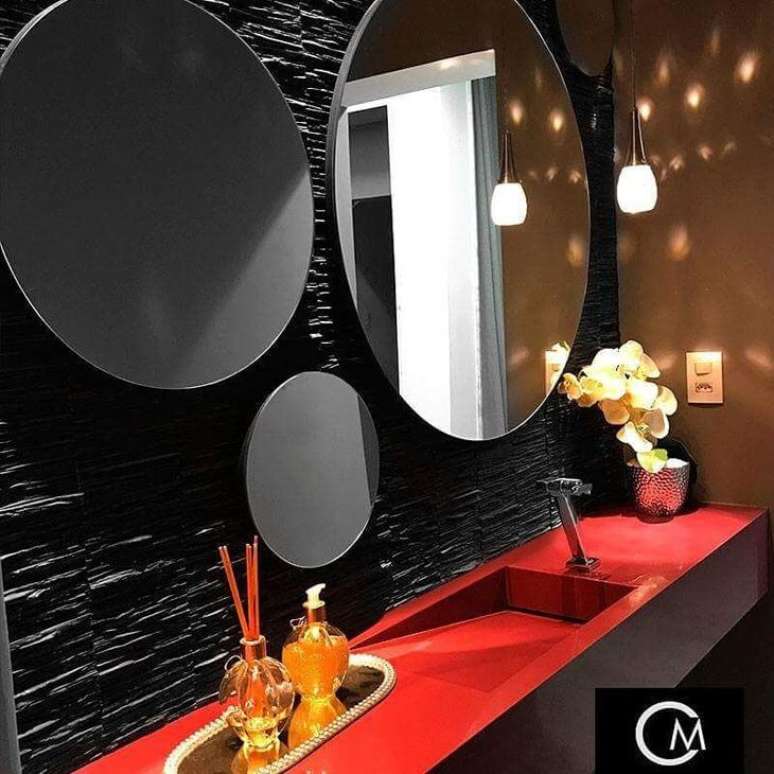 24. Banheiro com parede de filetes de ardósia preta, espelhos redondos e bancada vermelha – Foto Chiara Marcondes Arquitetura