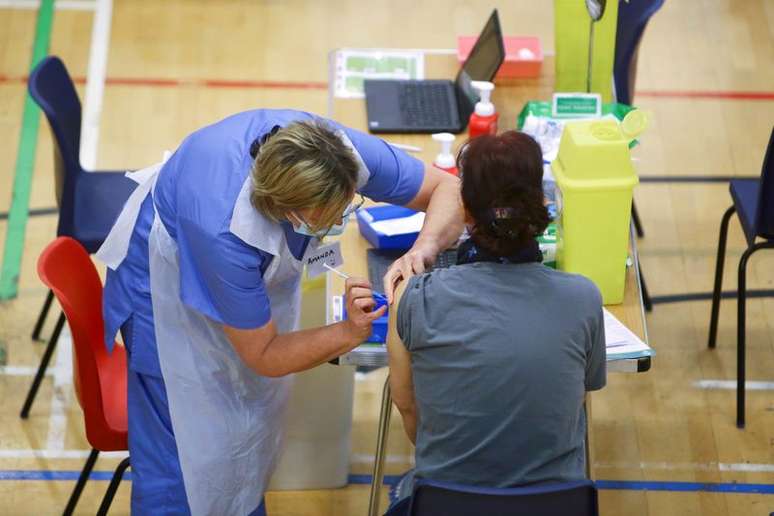 Mulher recebe aplicação de vacina da AstraZeneca contra Covid-19 no estádio de Cwmbran, em Gales do Sul, Reino Unido
17/02/2021 Geoff Caddick/Pool via REUTERS