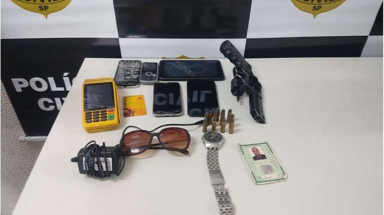 Objetos e rev&oacute;lver apreendidos com suspeito de participar de 'Quadrilha do Pix'