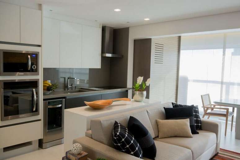 35. Decoração com móveis claros para cozinha aberta com sala de apartamento – Foto: Bordin & Soares