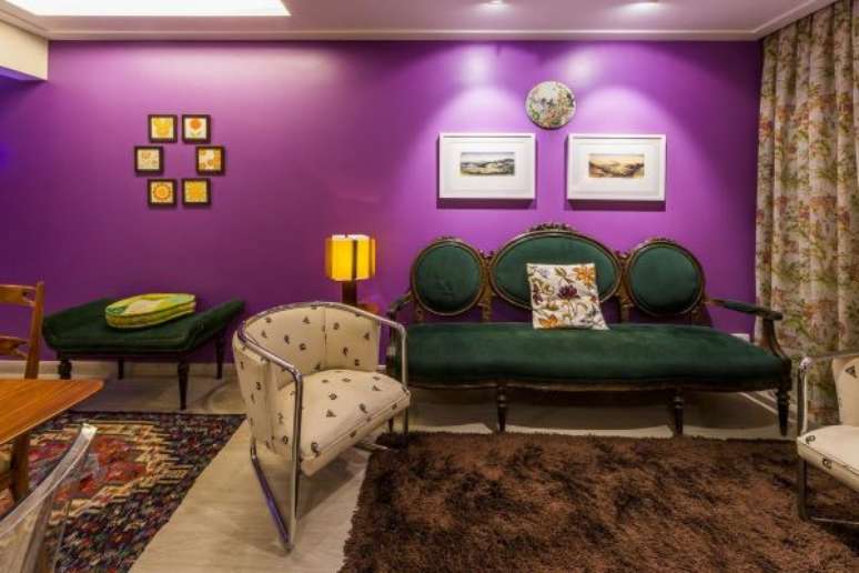 55. Sala com parede roxa e móveis vintage verde e madeira – Foto Enzo Sobocinski
