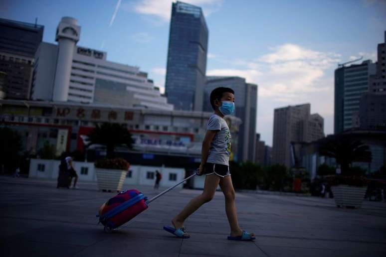 Menino de máscara protetora caminha perto da Estação Ferroviária de Xangai, cidade que registrou novos casos de coronavírus, China, 23 de agosto de 2021. REUTERS/Aly Song