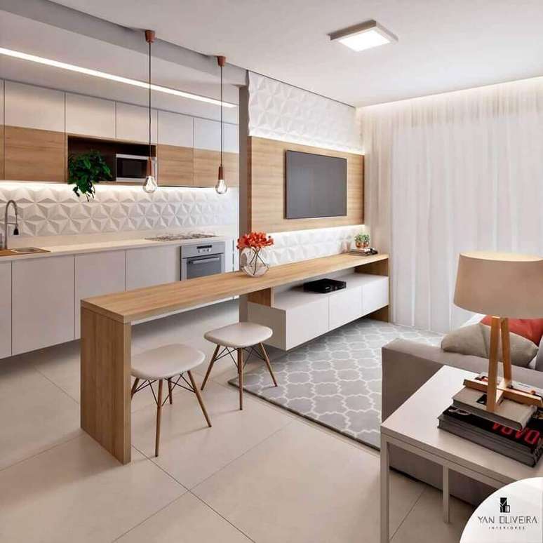 15. Bancada de madeira planejada para decoração de cozinha aberta com sala de TV – Foto: Yan Oliveira
