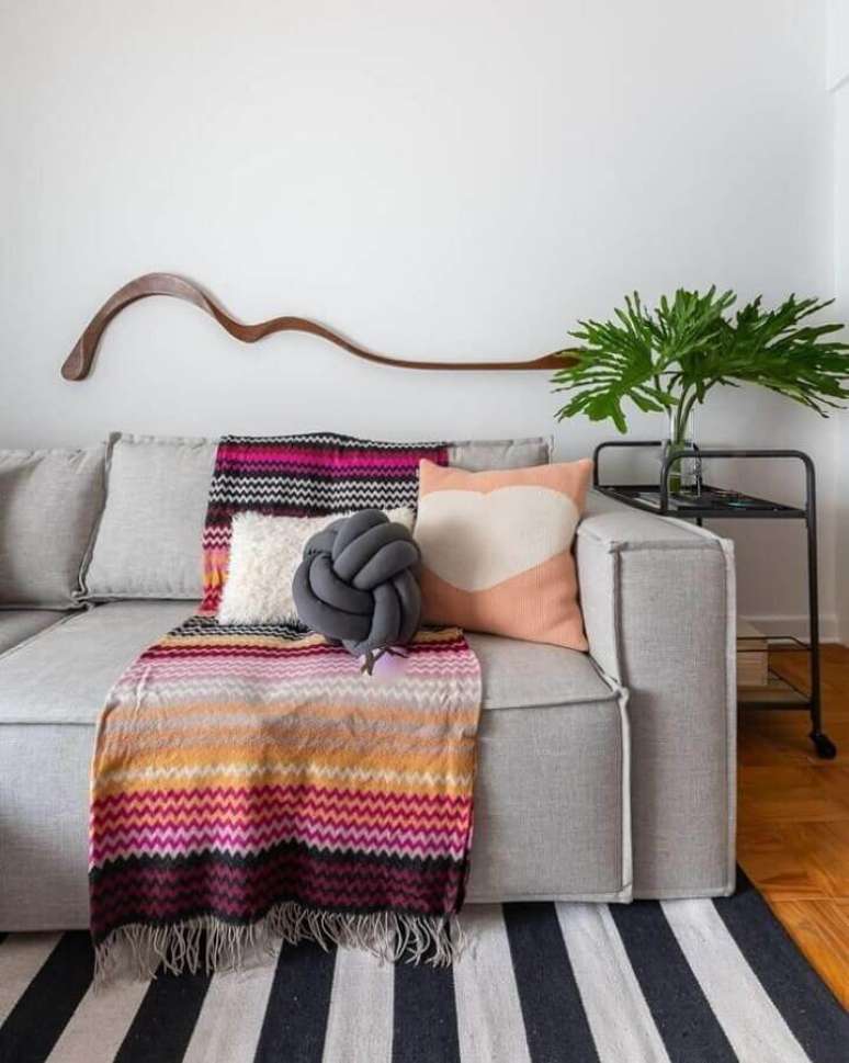 58. Sala simples decorada com manta e almofadas para sofá cinza – Foto: Gisele Rampazzo