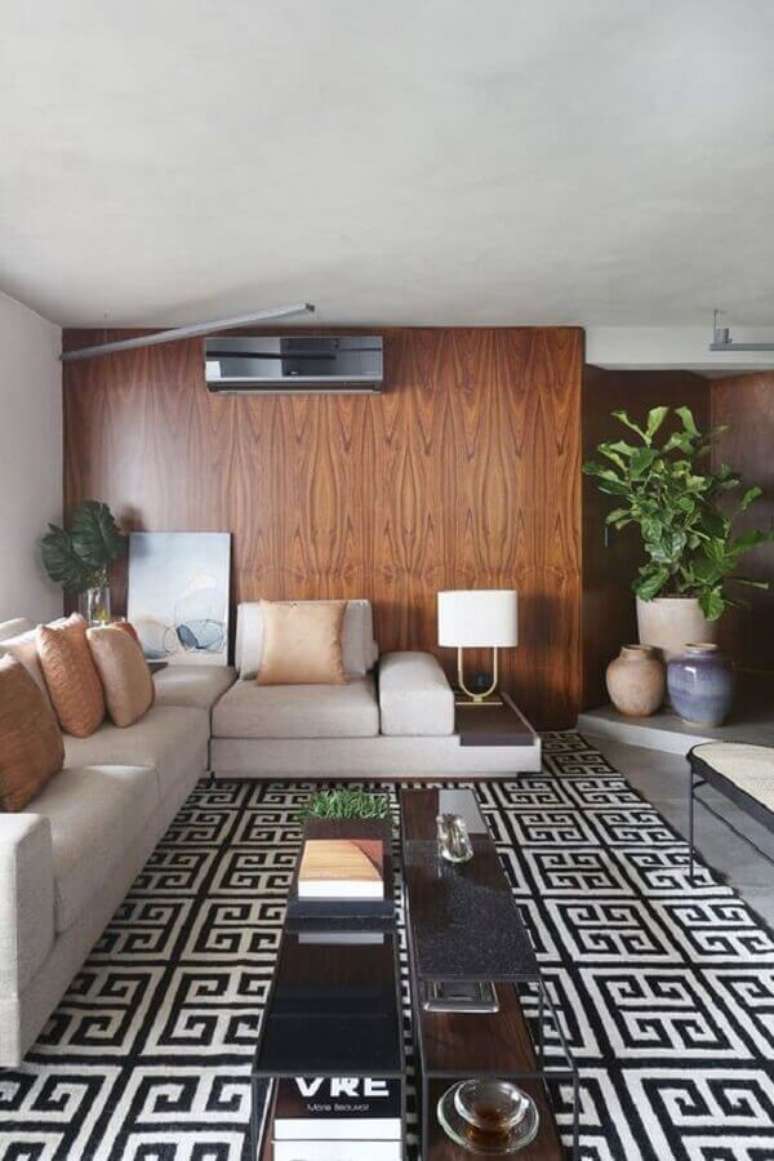 44. Parede de madeira para sala decorada com tapete geométrico e almofadas para sofá cinza claro – Foto: Casa Vogue