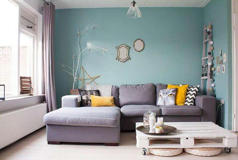 23. Decoração de sala com parede azul e almofadas para sofá cinza – Foto: Kyle Bunting