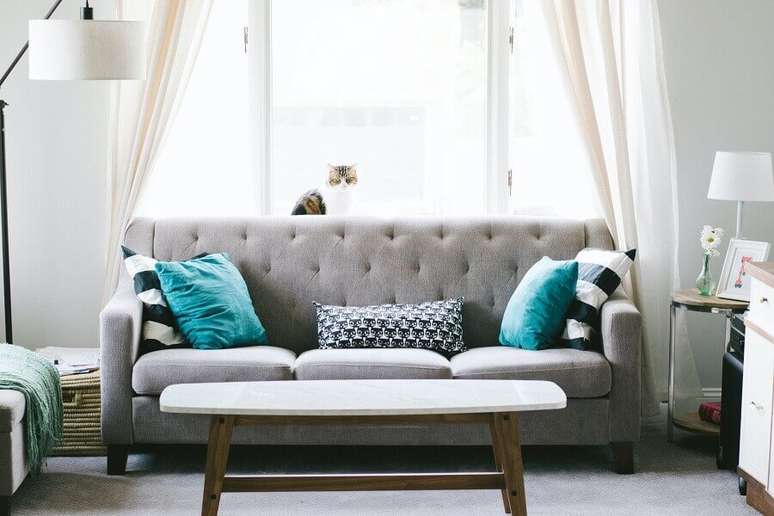 38. Decoração para sala de estar com abajur de piso e almofadas decorativas para sofá cinza – Foto: Unsplash