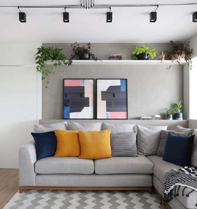 31. Decoração de sala moderna com trilho de luz e combinação de almofadas para sofá cinza de canto – Foto: Studio 92