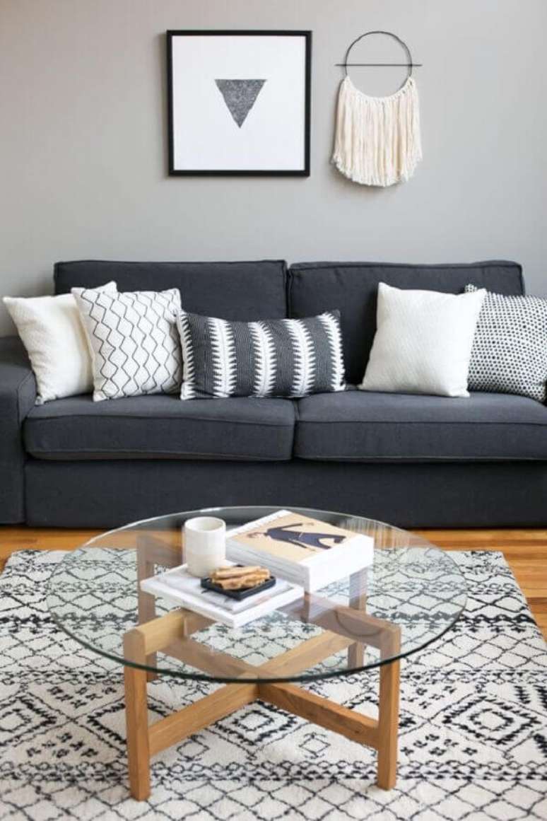 43. Mesa de centro redonda para sala simples decorada com almofadas para sofá cinza escuro – Foto: Apartment Therapy