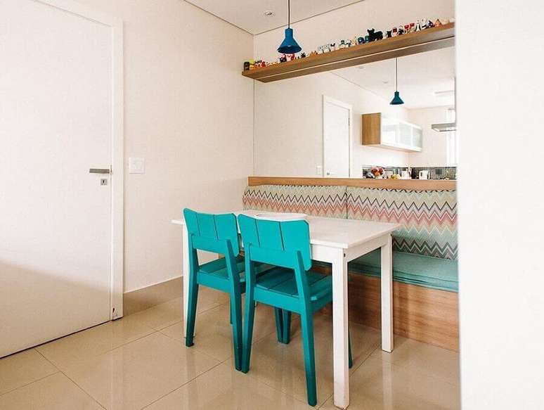 28. Cores para sala de jantar pequena e simples decorada com cadeira azul turquesa e parede espelhada – Foto: Codecorar