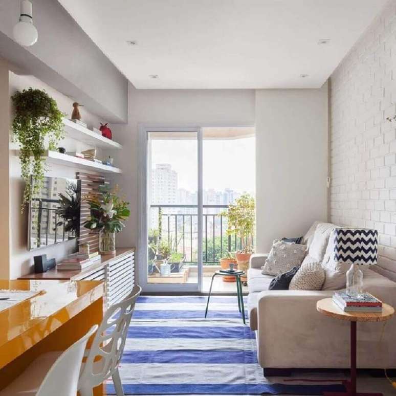 54. Ideia de cores para sala de estar pequena decorada com tapete listrado azul e branco – Foto: Tria Arquitetura