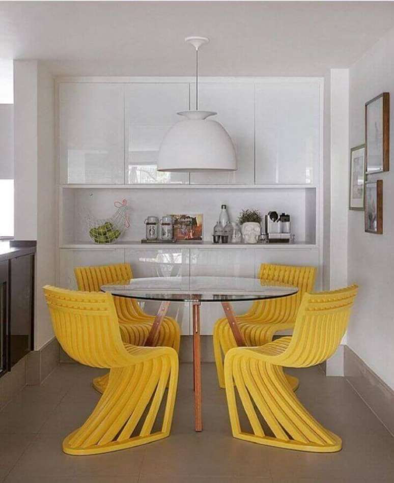19. Cores para sala de jantar pequena decorada com cadeiras amarelas para mesa de vidro redonda – Foto: Yamagata Arquitetura