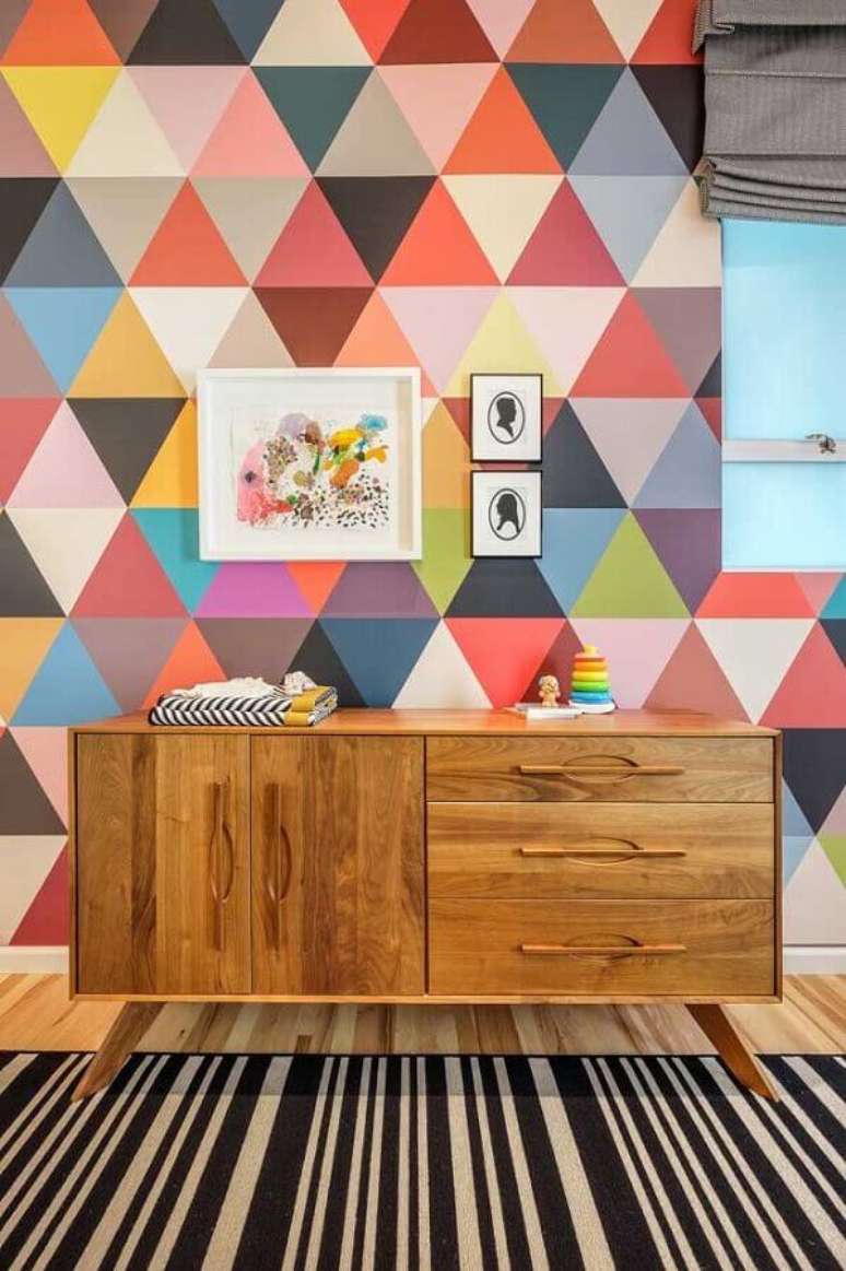 37. Cômoda de madeira para quarto decorado com papel de parede colorido e tapete listrado – Foto: Upper Terrace Nursery