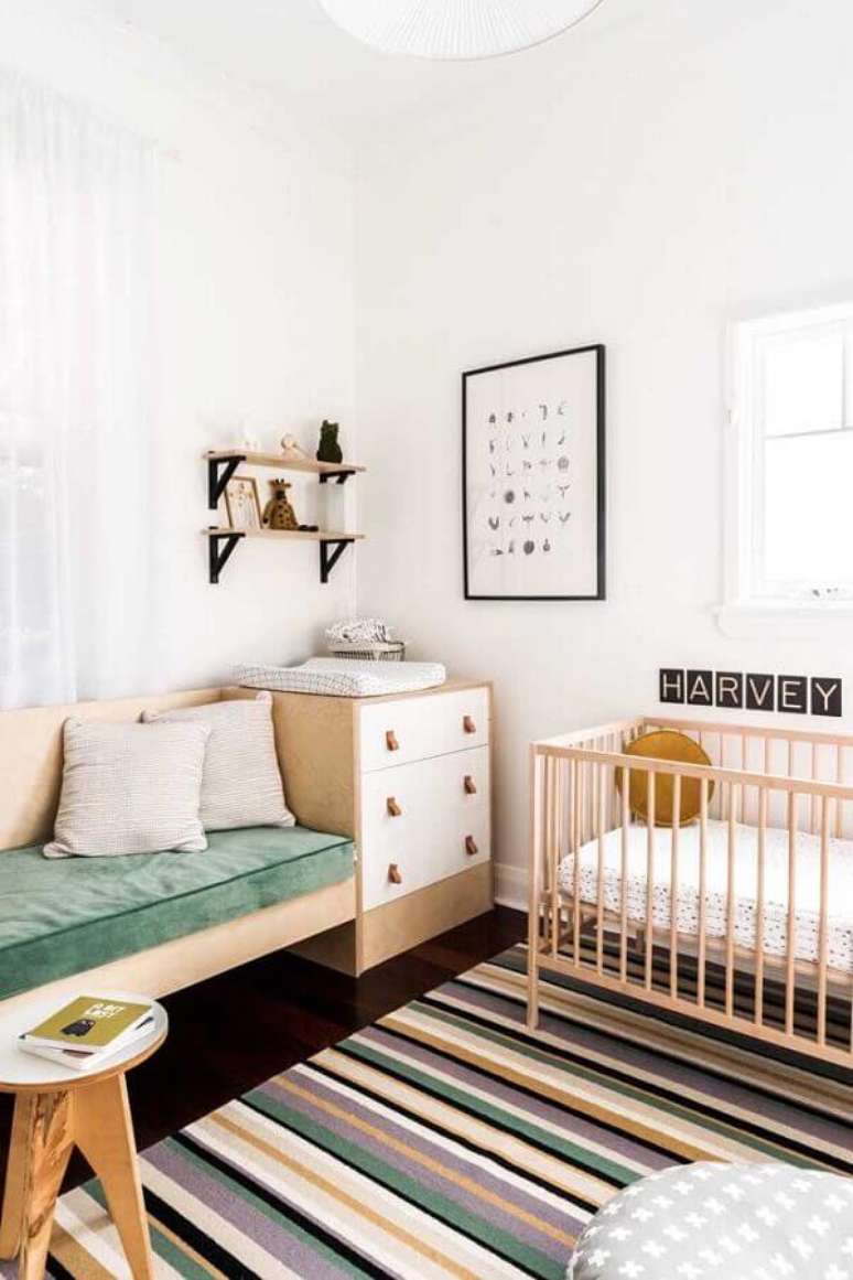 33. Cômoda de madeira para quarto de bebê simples decorado com tapete listrado – Foto: Nursery Design