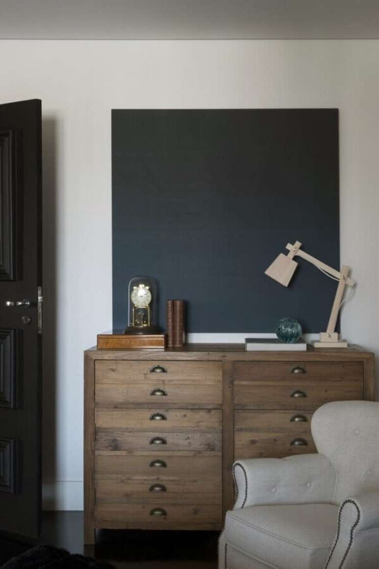 19. Cômoda antiga de madeira para decoração de quarto com poltrona cinza clara – Foto: Maurício Karam