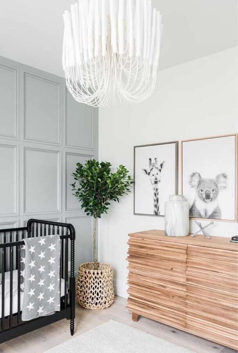 32. C&ocirc;moda de madeira para quarto de beb&ecirc; decorado com ber&ccedil;o preto e vaso de ch&atilde;o &ndash; Foto: No Decora