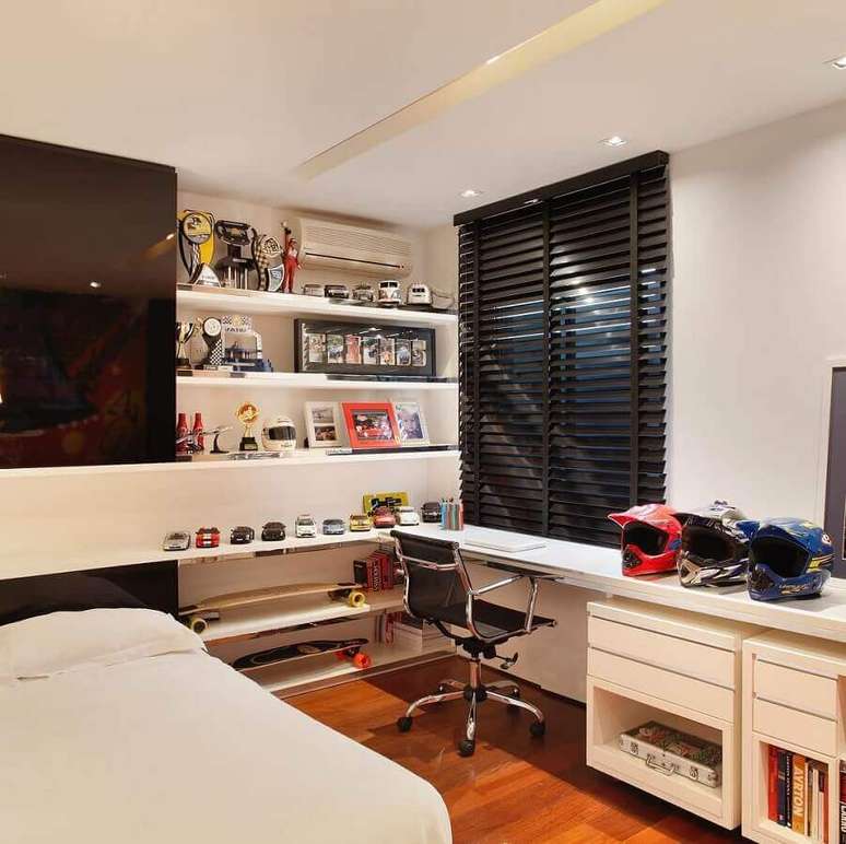 25. Decoração de quarto pequeno masculino com escrivaninha de canto e persiana preta – Foto: Juliana Affonso Arquitetura