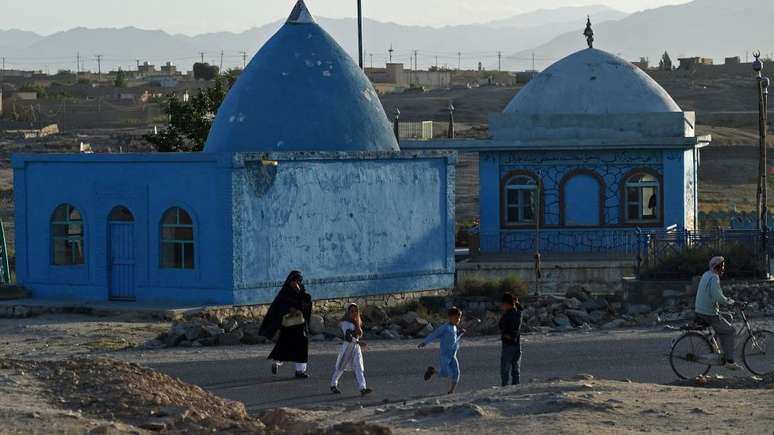 Pessoas passam por um santuário em Ghazni, cidade histórica do Afeganistão