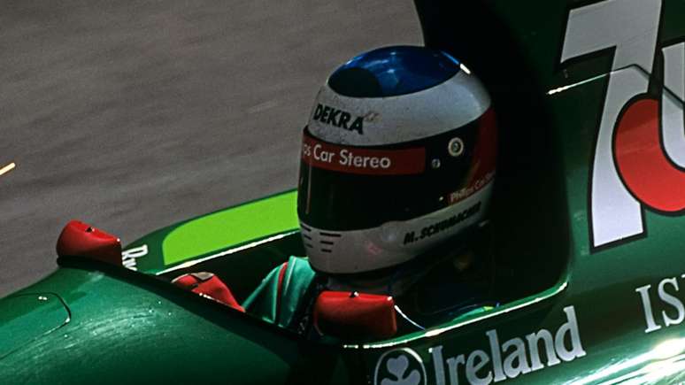 Michael Schumacher e o capacete que utilizou em seu ano de estreia na Fórmula 1