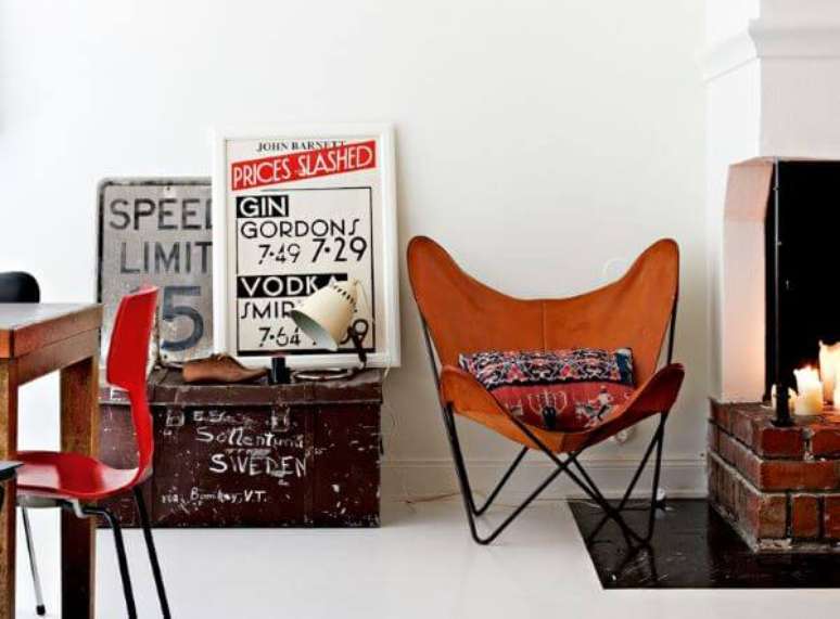46. Decora&ccedil;&atilde;o r&uacute;stica com poltrona butterfly laranja perto da lareira &ndash; Foto Elle Decoration Sweden