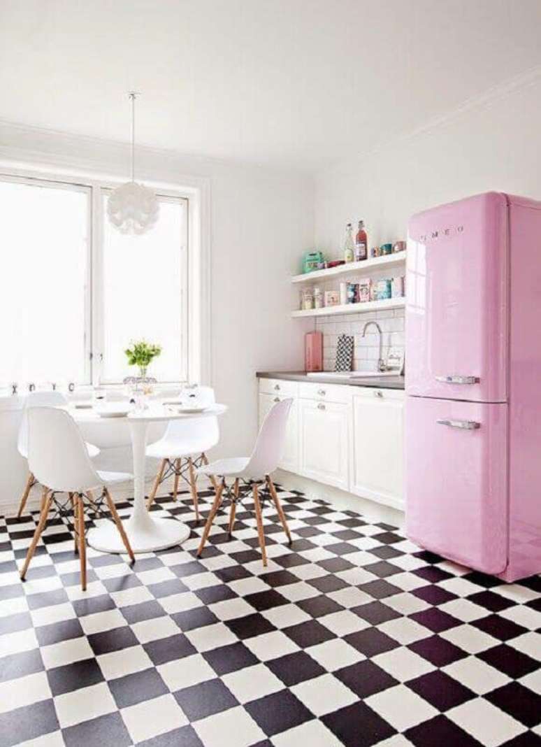 35. Piso preto e branco xadrez para cozinha branca decorada com geladeira rosa e mesa redonda – Foto: Roomed