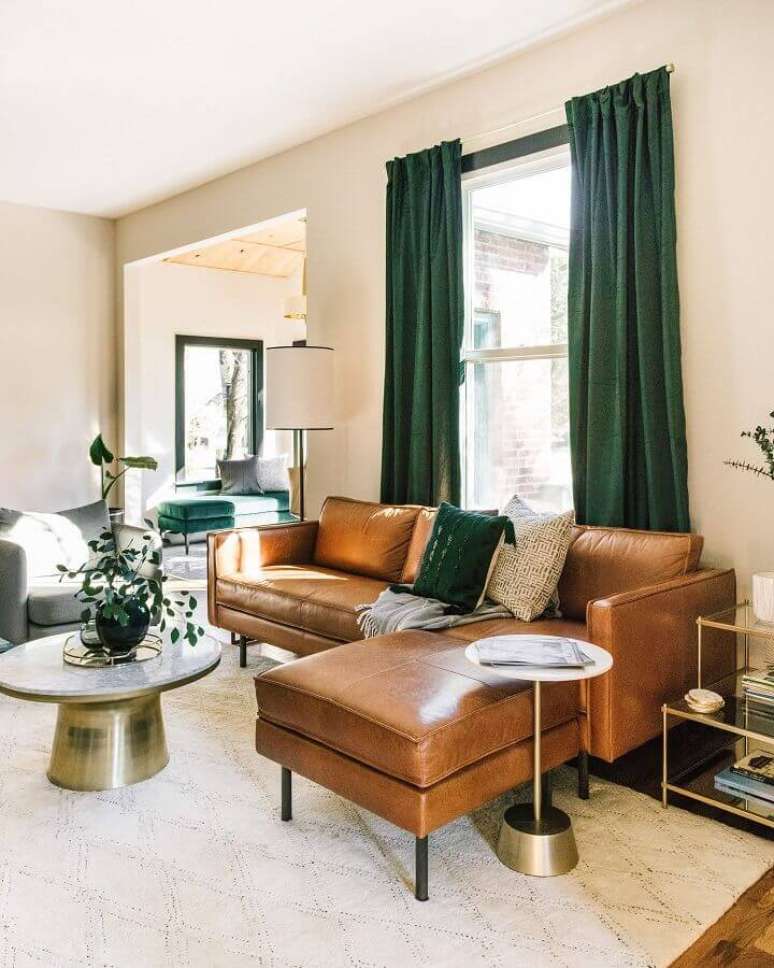 2. Tipos de sofás com chaise de couro para sala bege decorada com cortina verde – Foto: Estofos PT