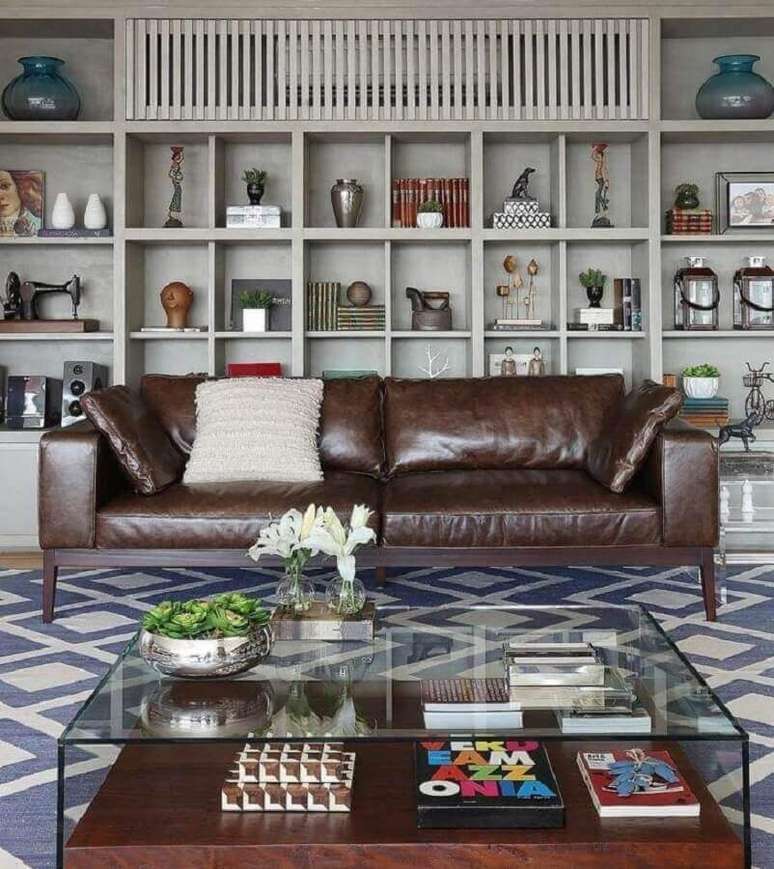 42. Tipos de sofás de couro para decoração de sala com estante de nichos e mesa de centro de vidro – Foto: Mariana Orsi Fotografia