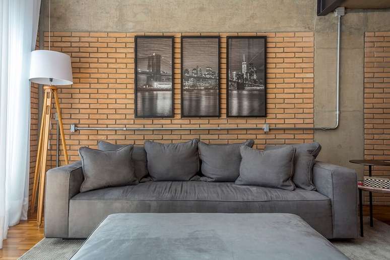 3. O sof&aacute; aconchegante se conecta com a poltrona de madeira. Foto: JP Image