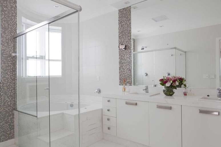 42. Gabinete branco para banheiro decorado com pastilhas e banheira de hidromassagem &ndash; Foto: Erica Salguero
